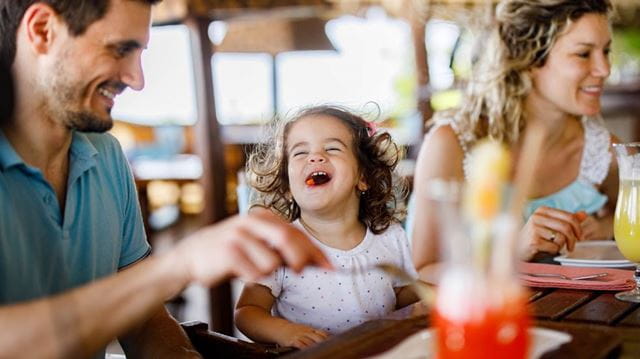 Little girl laughing in restaurant